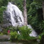 Waterfall flowing through dense green forest in Ranong Province
